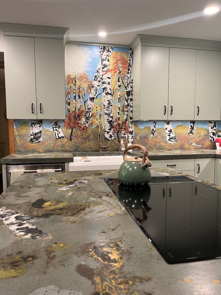 Kitchen with concrete backsplash that looks like birch trees and a forest