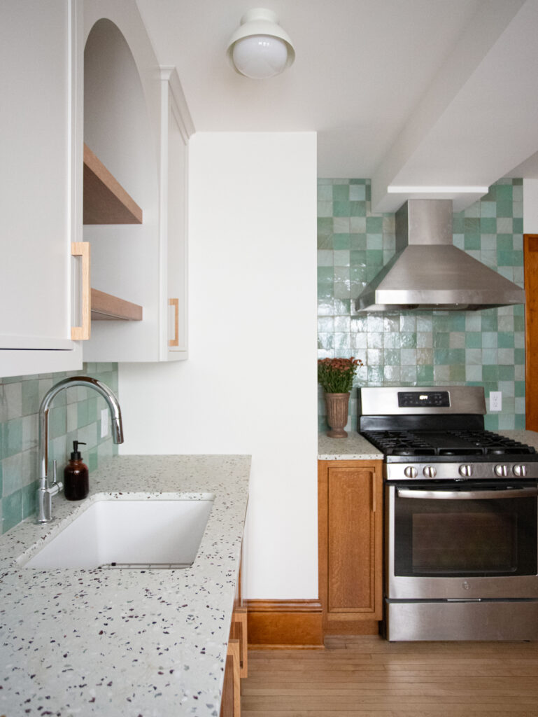 Kitchen with a green tile backsplash and concrete terrazzo countertops