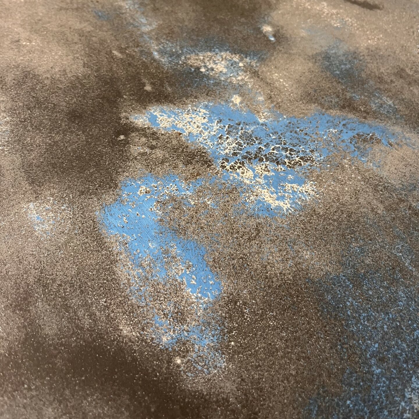 Close up view of grey concrete countertops with a pop of blue and white
